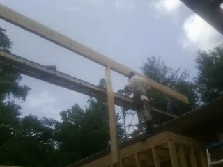 Carpenter setting a ridge beam over a new addition frame — Ice Dam Removal by Roofing Brothers in Union City